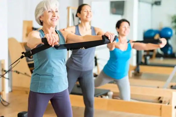 Toning Arms After 60: Empowering Womens Fitness Through Effective Weight Training 2 older woman doing weight training Nantwich and resistance in the gym to tone upper arms