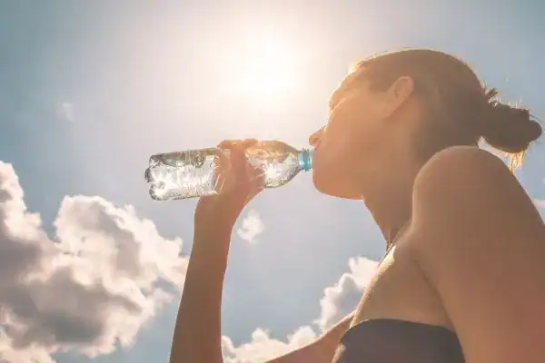 Hydration: The Secret Ingredient for a Toned Stomach and Enhanced Fitness 3 Image of woman drinking water to hydrate Nantwich after run.