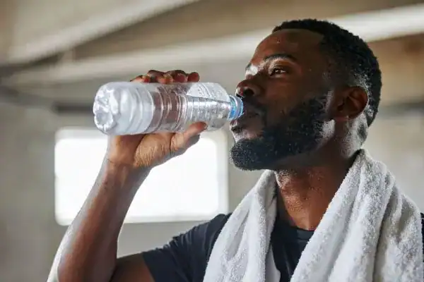 Hydration: The Secret Ingredient for a Toned Stomach and Enhanced Fitness 1 Image of man drinking water to improve hydration Nantwich after work out.